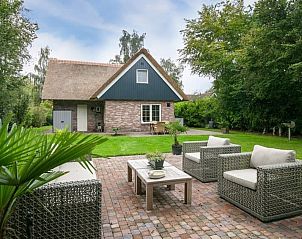 Stijlvolle woonkamer in vakantiehuis Tonmolen 4, Paasloo, Overijssel met modern interieur en uitzicht op groene omgeving.