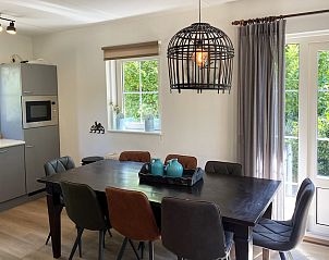 Gezellige eetkamer in vakantiehuis Otter 8, Paasloo, Overijssel met moderne keuken en uitzicht op de groene natuur.