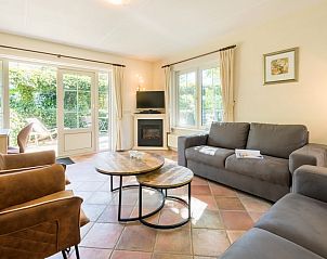 Gezellige woonkamer in vakantiehuis Tjasker 6, Paasloo, met comfortabele zithoek en uitzicht op groene tuin in Noordwest Overijssel.