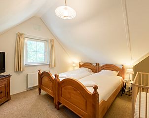 Sfeervolle slaapkamer in vakantiehuis Tjasker 6, Paasloo, Overijssel met houten bedden en natuurlijk licht.