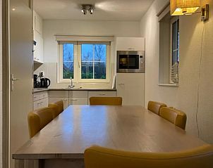 Gezellige eetkamer in Luxe Vakantievilla Weerribben, Paasloo, met uitzicht op de natuurlijke omgeving van Noordwest Overijssel.