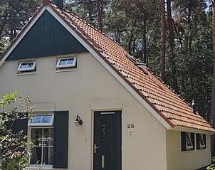 Rustieke buitenkant van Vakantiehuisje in IJhorst, omgeven door bos.