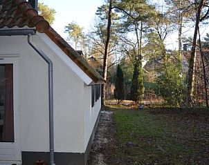 Zijaanzicht van Vakantiehuisje in IJhorst, Overijssel, met groene omgeving.