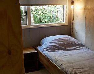Slaapkamer in Vakantiehuisje in IJhorst met eenpersoonsbed, gelegen in de rustige natuur van Overijssel.