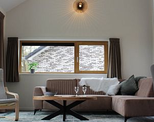 Gezellige woonkamer van Vakantiehuis in IJhorst, Noordwest Overijssel, met comfortabele zithoek en uitzicht op de landelijke omgeving.