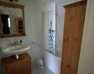 Stijlvolle badkamer van Vakantiehuis in IJhorst met ruime douche en houten accenten.