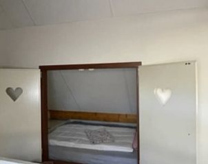 Knusse slaapkamer in Vakantiehuis in IJhorst met uniek ingebouwd bed en hartvormige details.