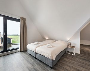 Sfeervolle slaapkamer in Watervilla 8, Ossenzijl, met uitzicht op water en groene omgeving in Noordwest Overijssel.