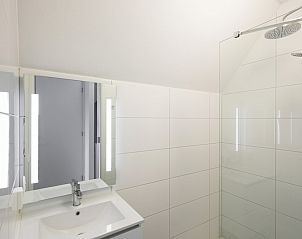 Moderne badkamer in Watervilla 8, een vakantiehuis in Ossenzijl, Noordwest Overijssel. Strakke witte tegels en ruime douche.