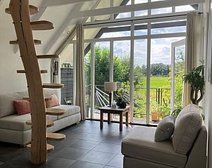 Lichte woonkamer met uitzicht op de tuin in Vakantiehuisje in Tuk, Noordwest Overijssel.