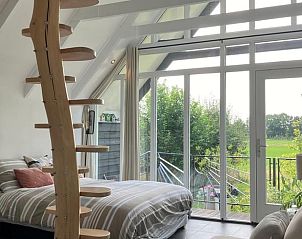 Slaapkamer in Vakantiehuisje in Tuk met moderne inrichting en tuinzicht in Noordwest Overijssel.