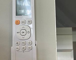 Afstandsbediening voor airconditioning in Vakantiehuisje in Tuk, zorgt voor comfort in Noordwest Overijssel.