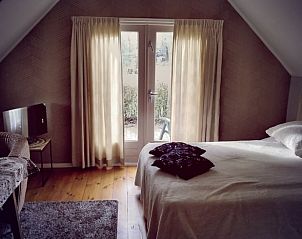 Ruime slaapkamer met uitzicht in Huisje in Eesveen, serene omgeving in Noordwest Overijssel.