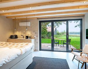 Sfeervolle slaapkamer van Huisje in Staphorst, vakantiehuis in Overijssel, met uitzicht op de rustgevende natuur.