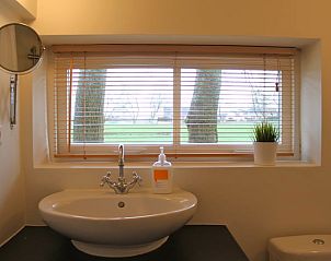 Badezimmer mit Waschbecken und Fenster im Ferienhaus in Abcoude, bietet Blick auf die Natur in Utrecht Nord.