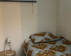 Gezellige slaapkamer in Huisje in Abcoude, Utrecht noord, met palmbladeren beddengoed voor een ontspannen vakantieverblijf.