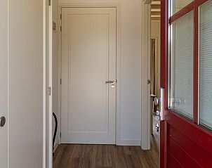 Ingang van het vakantiehuis Huisje in Abcoude, Utrecht noord, met stijlvolle rode deur.