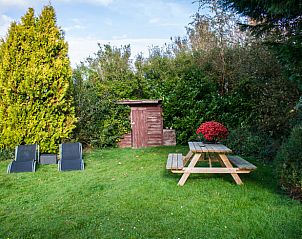 Buitenruimte met picknicktafel bij Huisje in Vinkeveen, vakantiehuis in Utrecht noord, Utrecht omringd door groen.