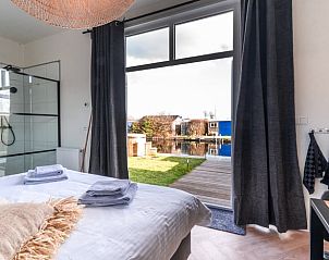 Slaapkamer met uitzicht op het water in Vakantiehuis in Vinkeveen, Utrecht.