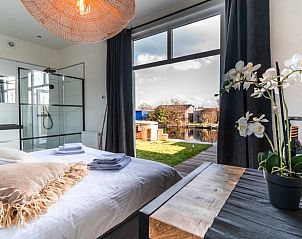 Slaapkamer met uitzicht in Vakantiehuisje in Vinkeveen, Utrecht, voor een ontspannen sfeer.