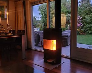 Sfeervolle woonkamer met open haard in Huisje in Vinkeveen, vakantieaccommodatie in Utrecht.