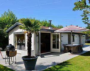 Zonnig terras bij Huisje in Vinkeveen, vakantiehuis in Utrecht met barbecue en parasol.