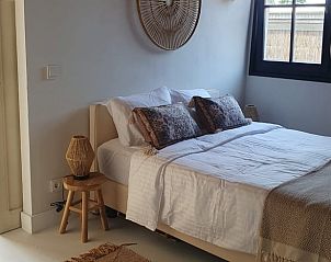 Gezellige slaapkamer in Huisje in Vinkeveen, Utrecht, met zachte handdoeken en warme sfeer voor een ontspannen verblijf.