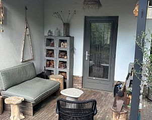 Gezellige zithoek op de veranda van Vakantiehuisje in Baarn, Utrecht noord, perfect voor ontspanning.