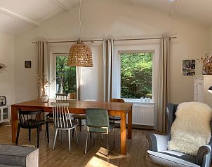 Eetruimte in Vakantiehuisje in Baarn, Utrecht noord, met houten tafel en uitzicht op de groene omgeving.