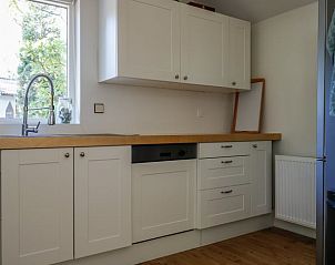 Moderne keuken in Vakantiehuisje in Baarn, Utrecht noord, met witte kasten en houten werkblad.