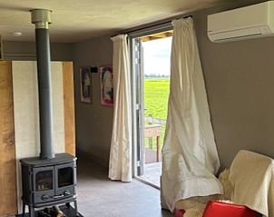 Comfortabele woonkamer met houtkachel in Vakantiehuis in Baambrugge, Utrecht noord.