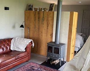 Sfeervolle zithoek met leren bank in Vakantiehuis in Baambrugge, Utrecht noord.