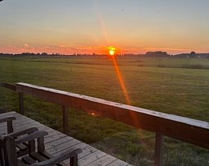 Romantisch uitzicht vanaf de veranda bij zonsondergang in Vakantiehuis in Baambrugge, Utrecht noord.