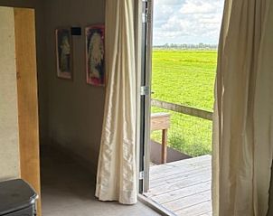 Binnenruimte met open deuren naar het terras in Vakantiehuis in Baambrugge, Utrecht noord.