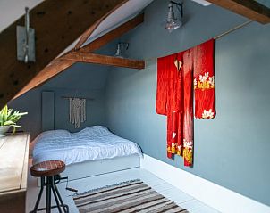 Unieke slaapkamer in Huisje in Waverveen, vakantiehuis in Utrecht met houten balken en rode kimono.