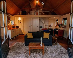 Gemtlicher Innenbereich des Ferienhauses in Eemnes, Utrecht Nord, mit bequemen Sitzgelegenheiten und rustikalen Holzelementen.