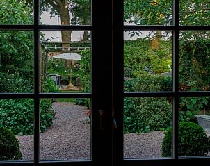 Blick auf den Garten vom Wohnzimmer des Ferienhauses in Eemnes, Utrecht Nord, umgeben von ppiger Natur.