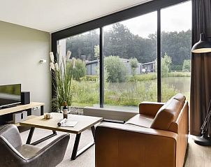 Moderne zithoek in Amerongse Berg 4-persoons woning 4EL1, Overberg, met uitzicht op de groene omgeving.