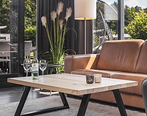 Gezellige zithoek met uitzicht op terras in Amerongse Berg bungalow, Utrecht.