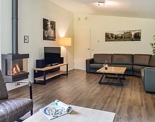 Moderne zithoek met open haard in Amerongse Berg vakantiehuis in Overberg, Utrechtse Heuvelrug, Utrecht.