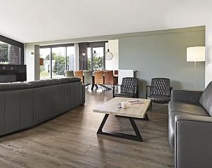 Gezellige woonkamer met grote ramen in Amerongse Berg vakantiehuis, Overberg, Utrecht.