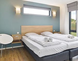 Slaapkamer met uitzicht op natuur in Amerongse Berg vakantiehuis, Utrechtse Heuvelrug.