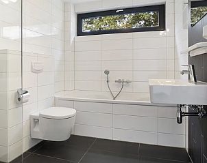 Badkamer met bad en toilet in Amerongse Berg 6-persoons vakantiehuis, Utrechtse Heuvelrug, Overberg.