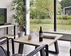 Moderne woonkamer met grote ramen in de Amerongse Berg 4-persoons bungalow, gelegen in Overberg, Utrecht.