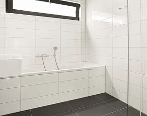 Moderne badkamer met bad in de Amerongse Berg 4-persoons woning, ideaal voor ontspanning in Overberg, Utrecht.