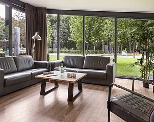 Gezellige woonkamer met grote ramen in Amerongse Berg 6-persoons kinderwoning, Overberg, Utrechtse Heuvelrug.