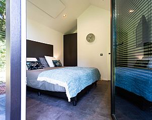 Slaapkamer in Lodge Royal Eco, Utrechtse Heuvelrug, met moderne inrichting en uitzicht in Lage Vuursche.