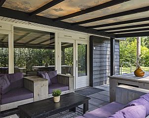 Ontspan op de overdekte veranda van Bungalow Schoonoord in Doorn, Utrechtse Heuvelrug, met uitzicht op de groene omgeving.