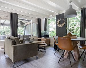 Gezellige woonkamer in Bungalow Schoonoord, Doorn, Utrechtse Heuvelrug. Comfortabele inrichting met uitzicht op groene natuur.