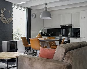 Gezellige woonkamer van Bungalow Schoonoord in Doorn, Utrechtse Heuvelrug. Comfortabele vakantiehuis sfeer met moderne keuken en zithoek.